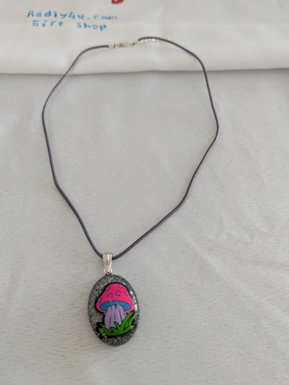 Necklace with a pendant featuring a pink mushroom design on a light gray background.