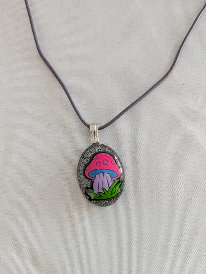 Necklace with a pendant featuring a colorful mushroom design on a light gray background
