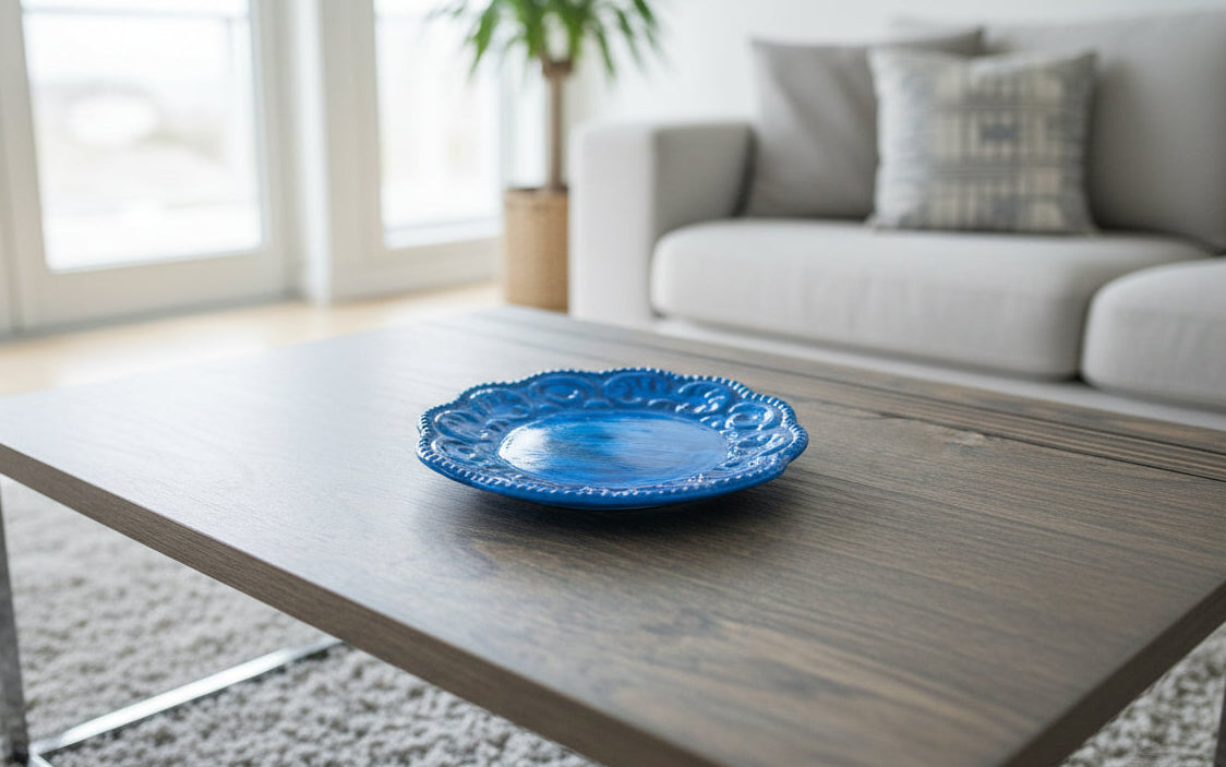 Blue decorative plate on a wooden coffee table in a living room.