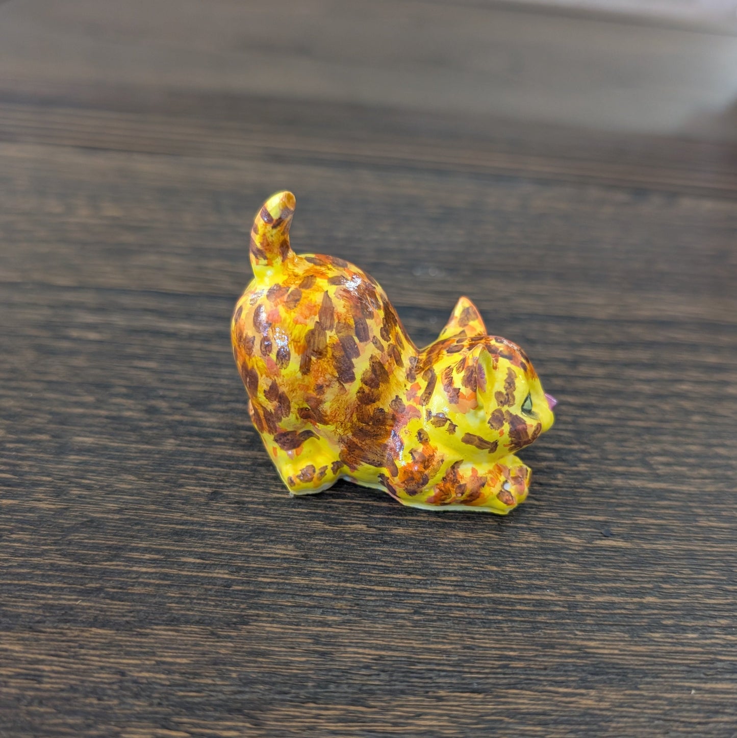 Decorative ceramic cat figurine  on a wooden surface