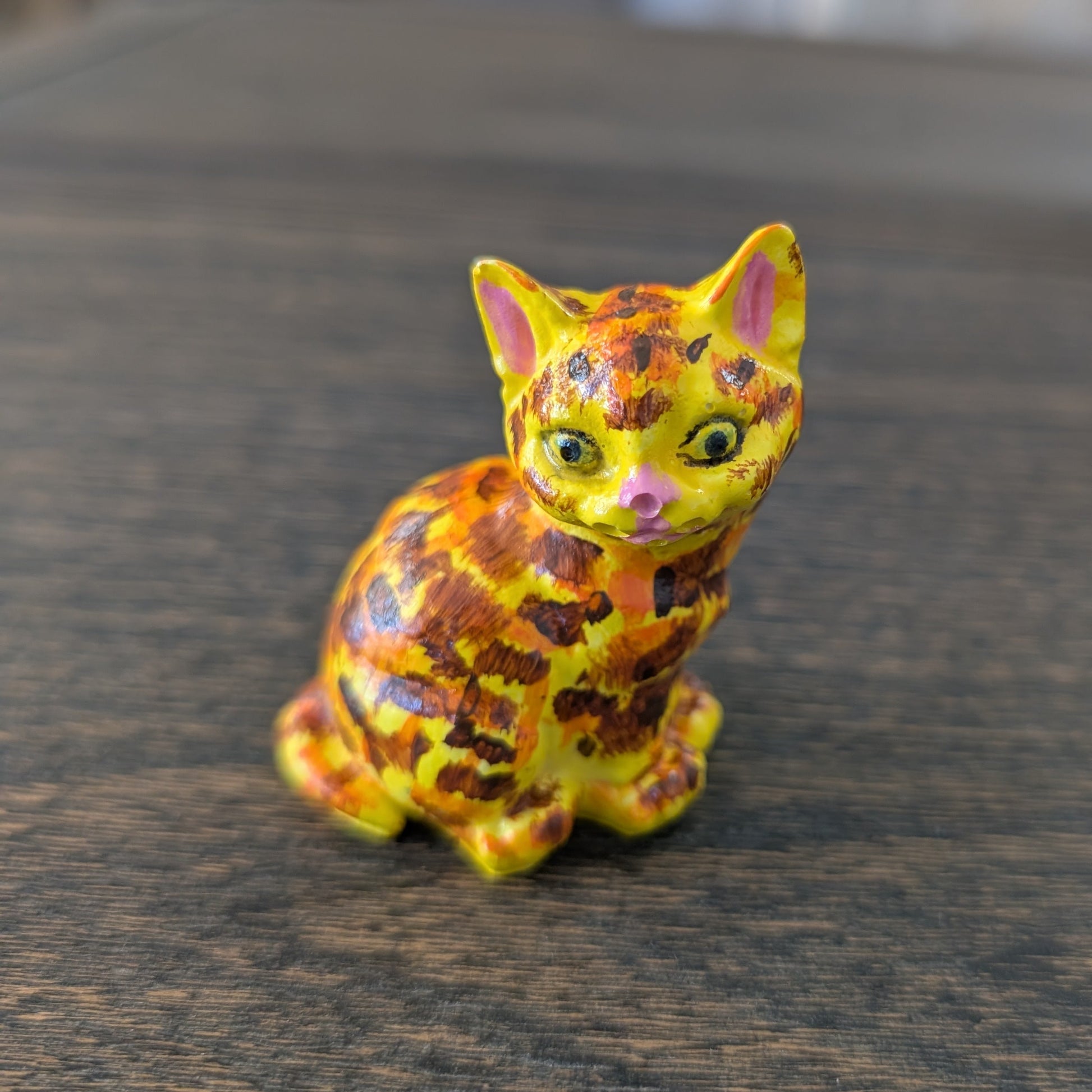 Colorful cat figurine on a wooden surface