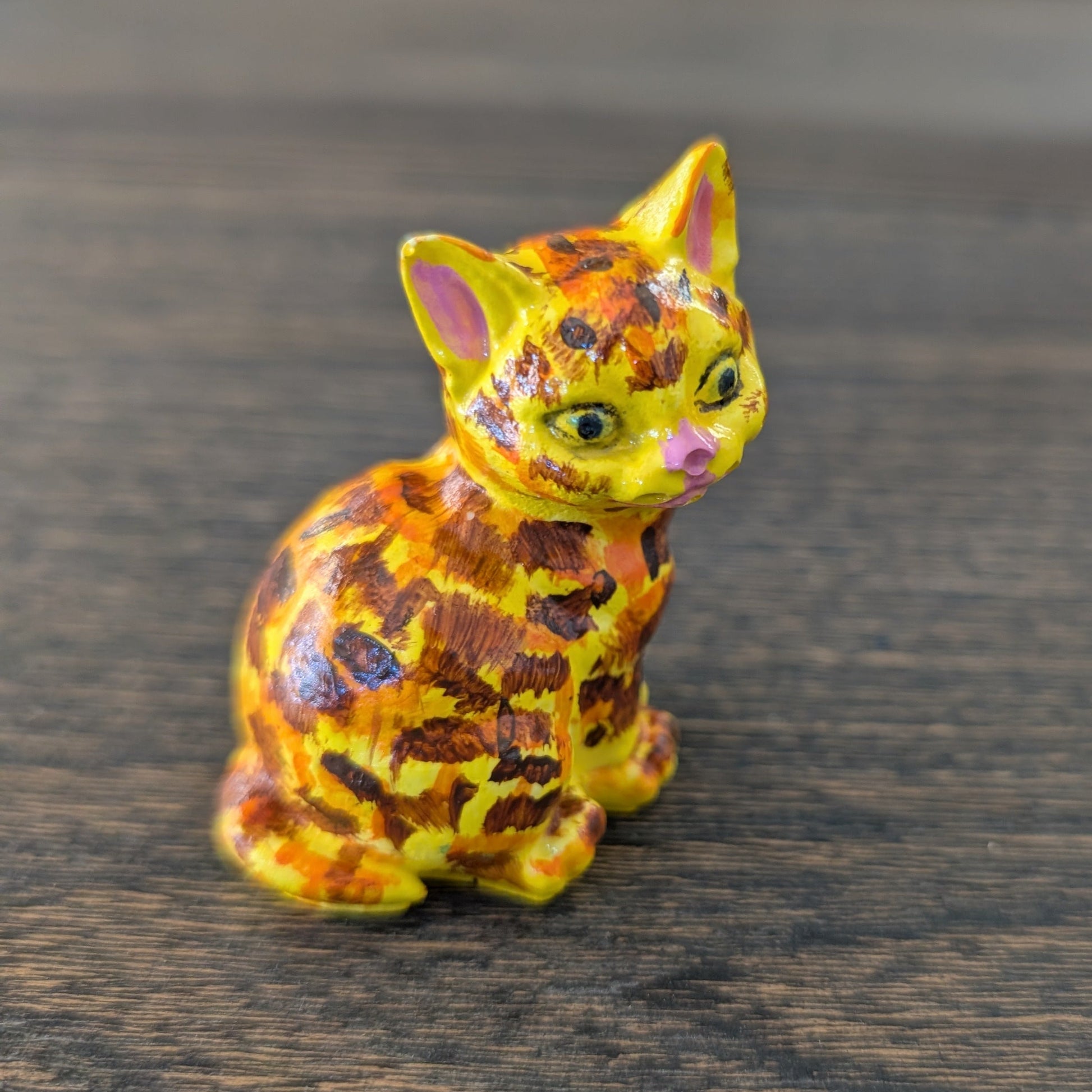 Colorful cat figurine on a wooden surface