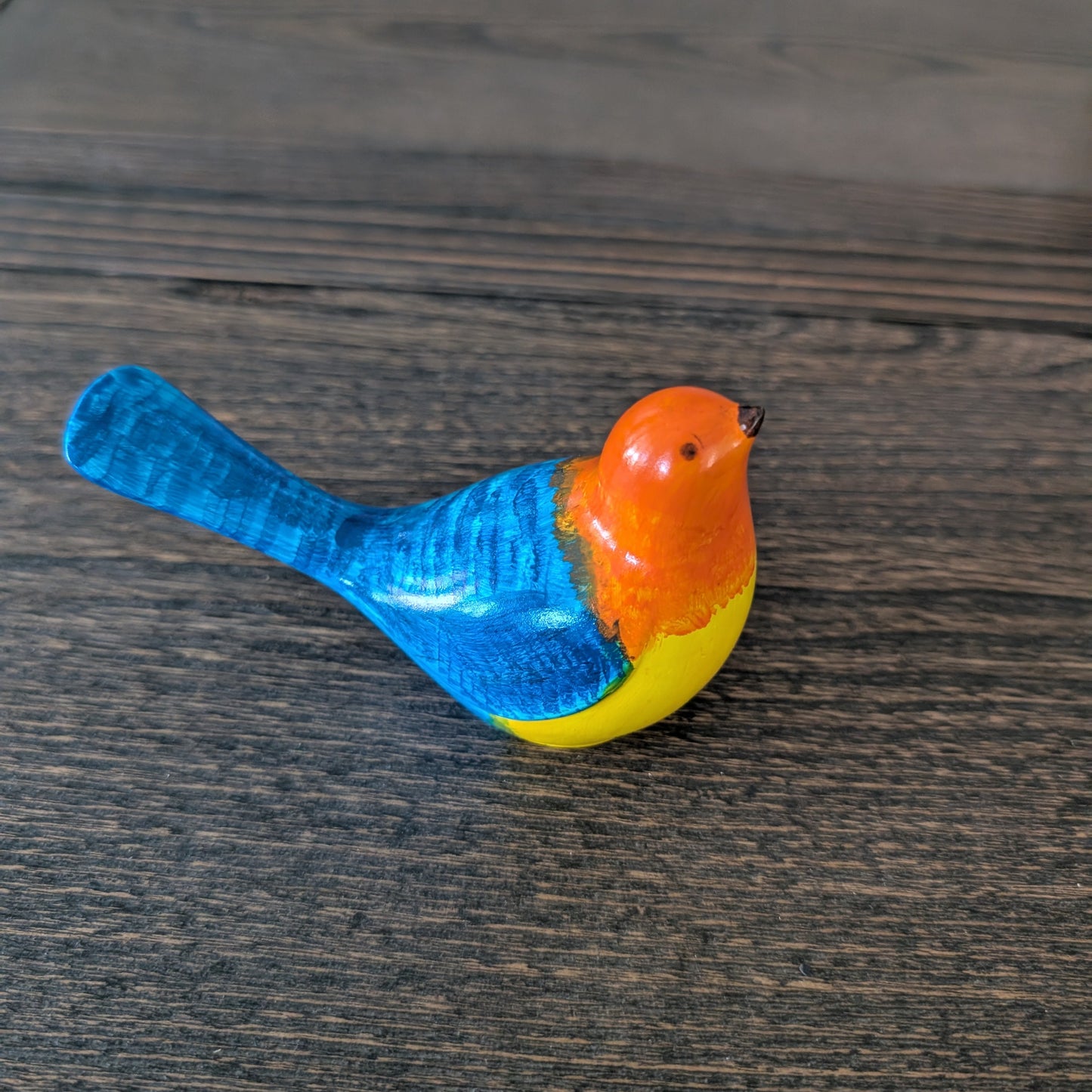 Colorful bird figurine on a wooden surface