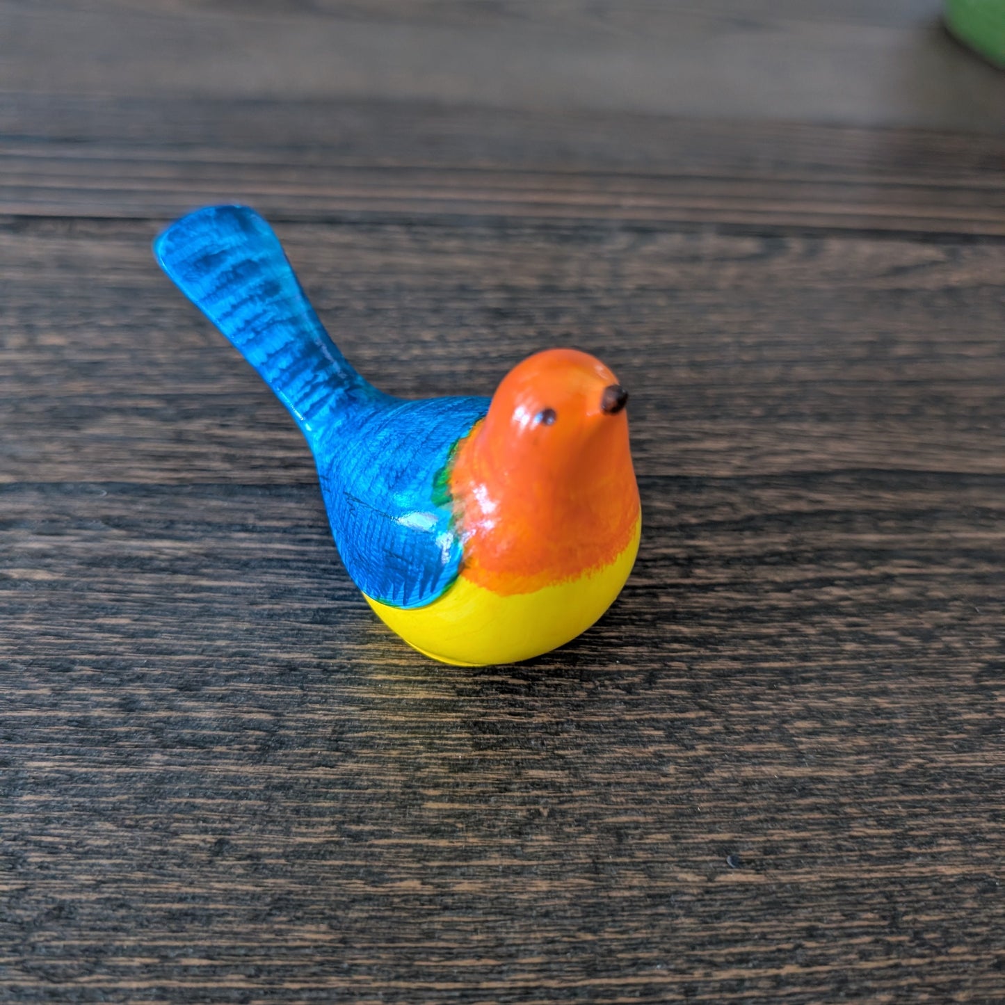 Colorful bird figurine on a wooden surface