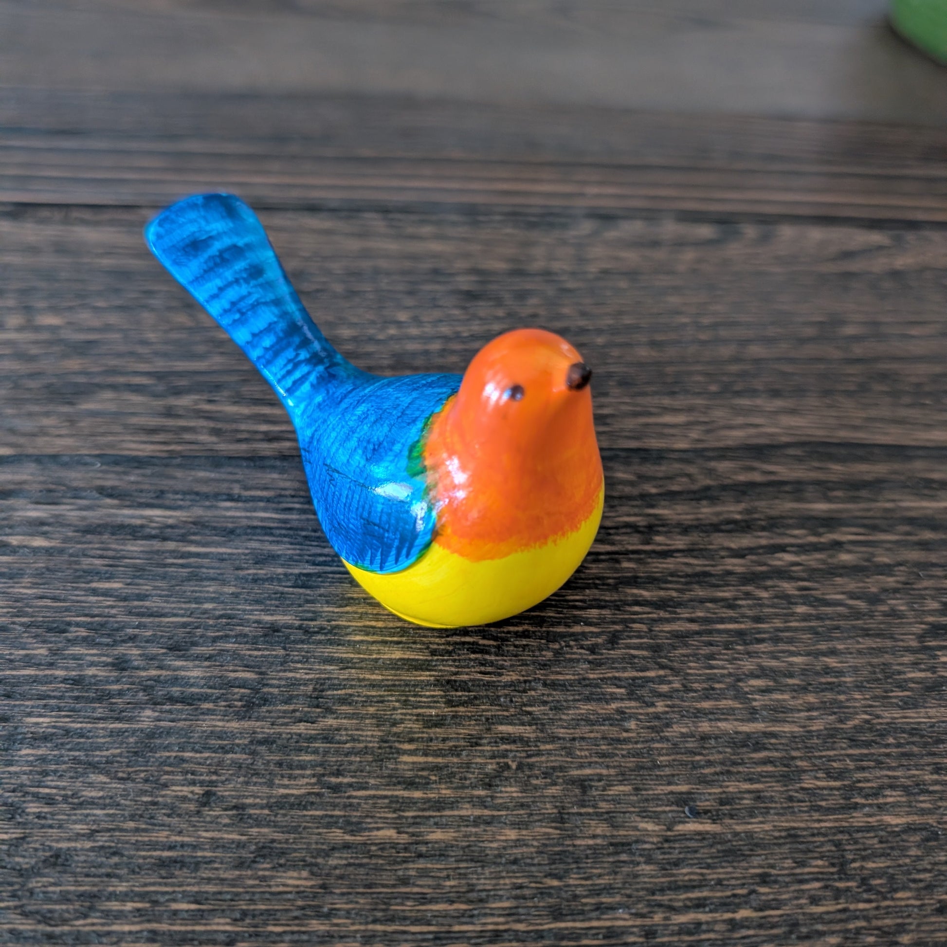 Colorful bird figurine on a wooden surface