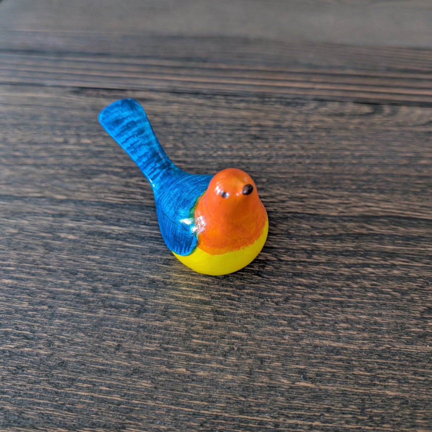 Colorful bird figurine on a wooden surface