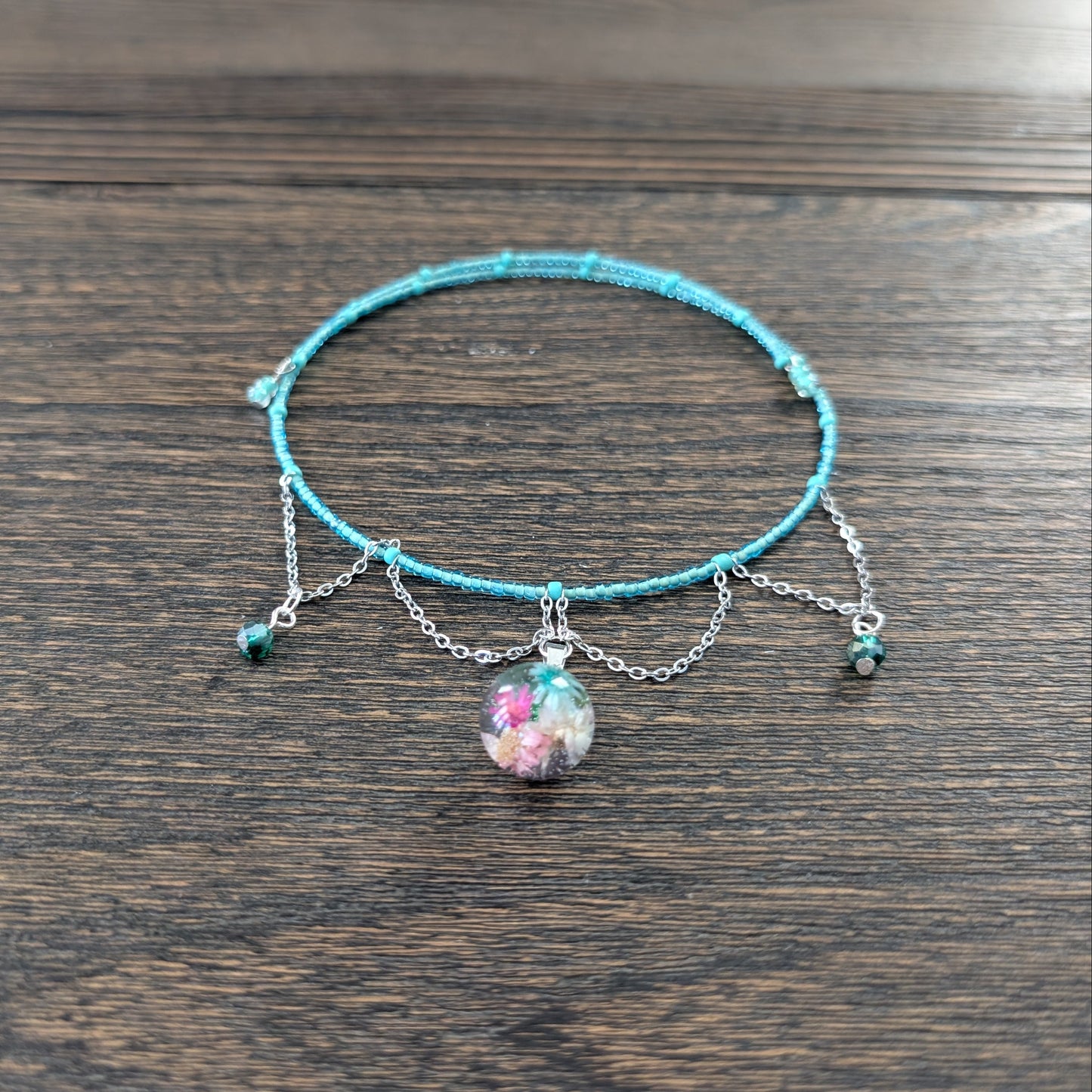 Turquoise necklace with charms on a wooden surface