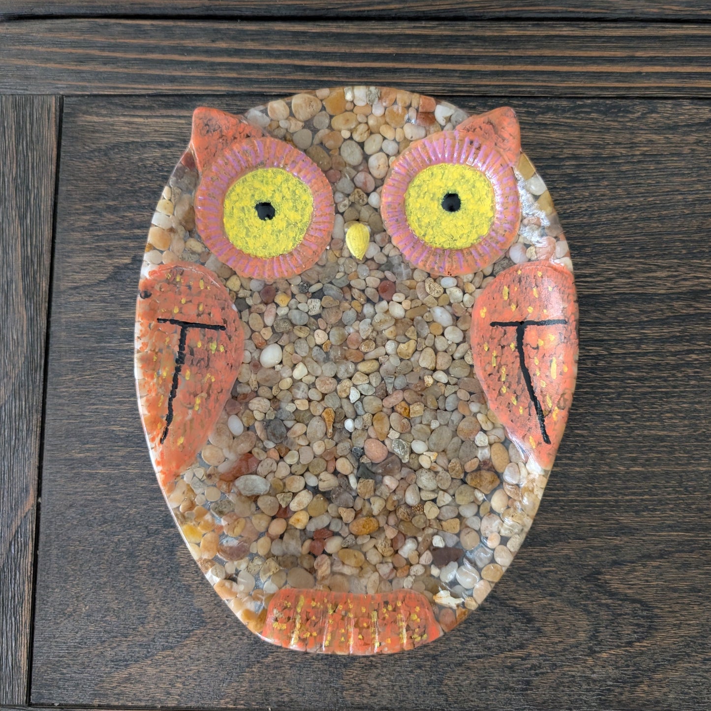 resin with rocks owl art piece on a wooden surface