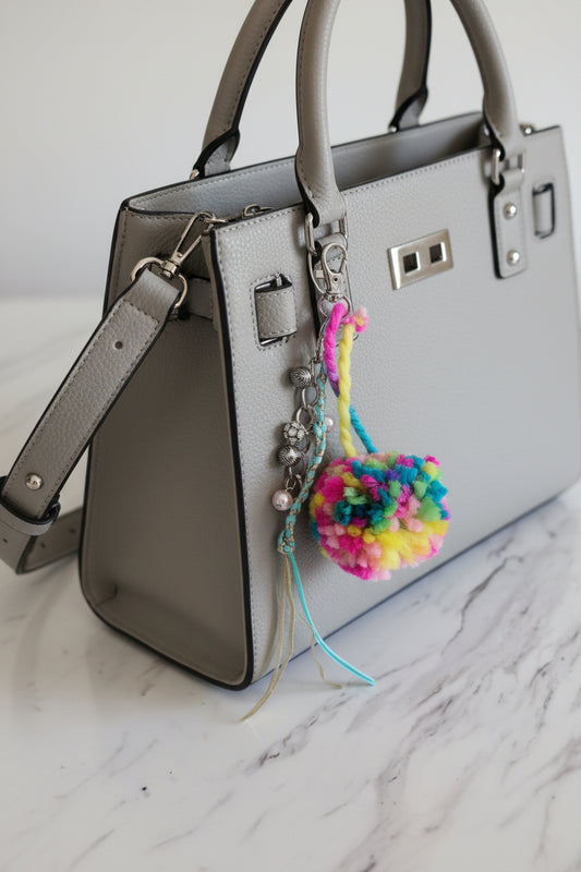 Colorful pom-pom keychain with rhinestones on a bag