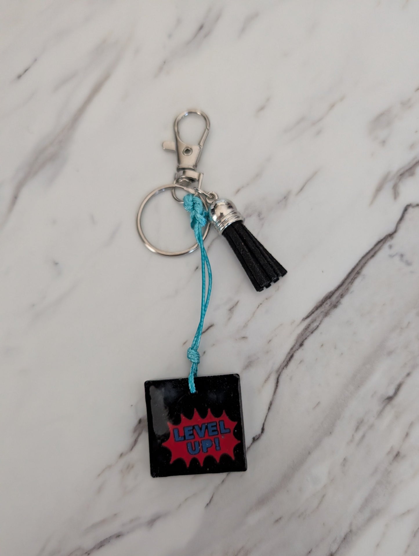 Keychain with 'Level Up!' design on a marble surface