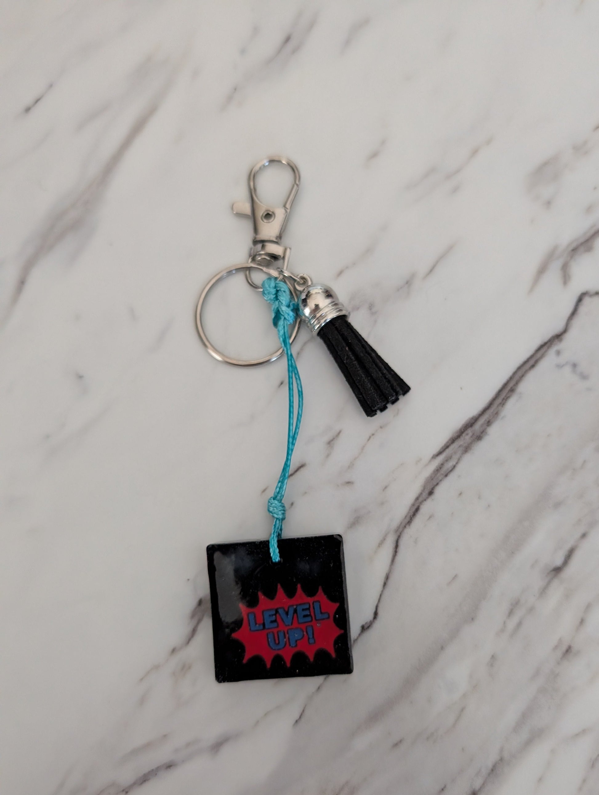 Keychain with 'Level Up!' design on a marble surface