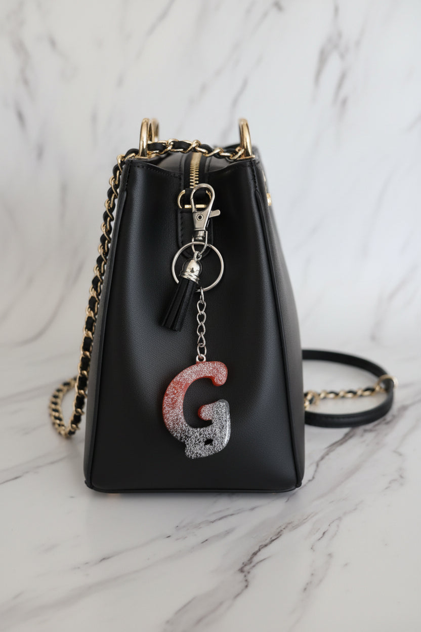 Keychain with a letter G on a marble surface