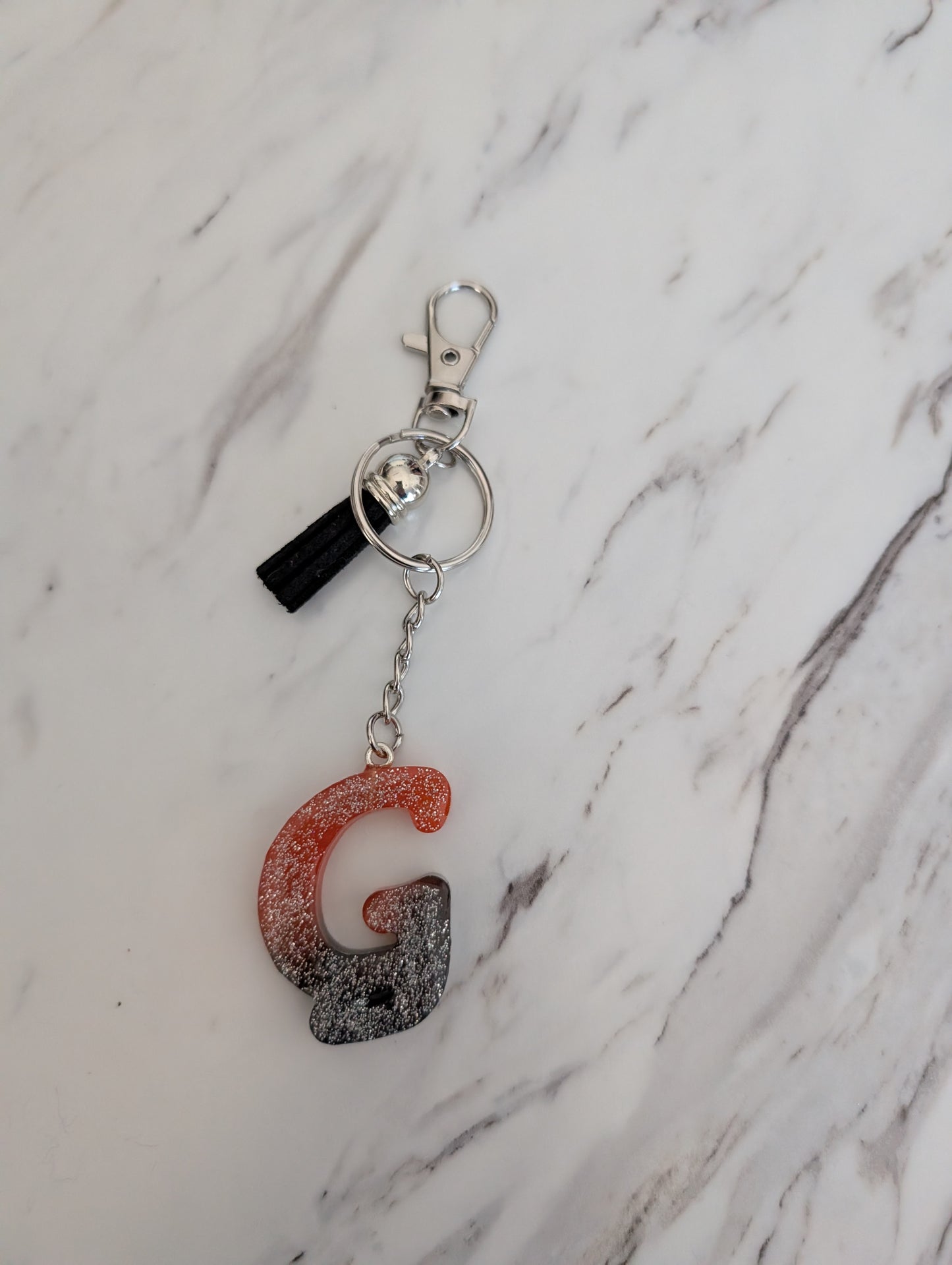 Keychain with letter 'G' on a marble background