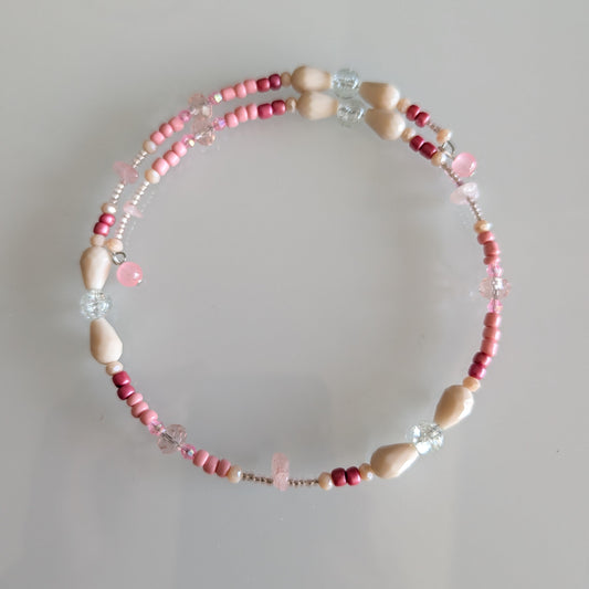 Artisan coil choker with a gradient of matte cream glass beads and rose-tinted crystals, designed without a clasp for a seamless look.