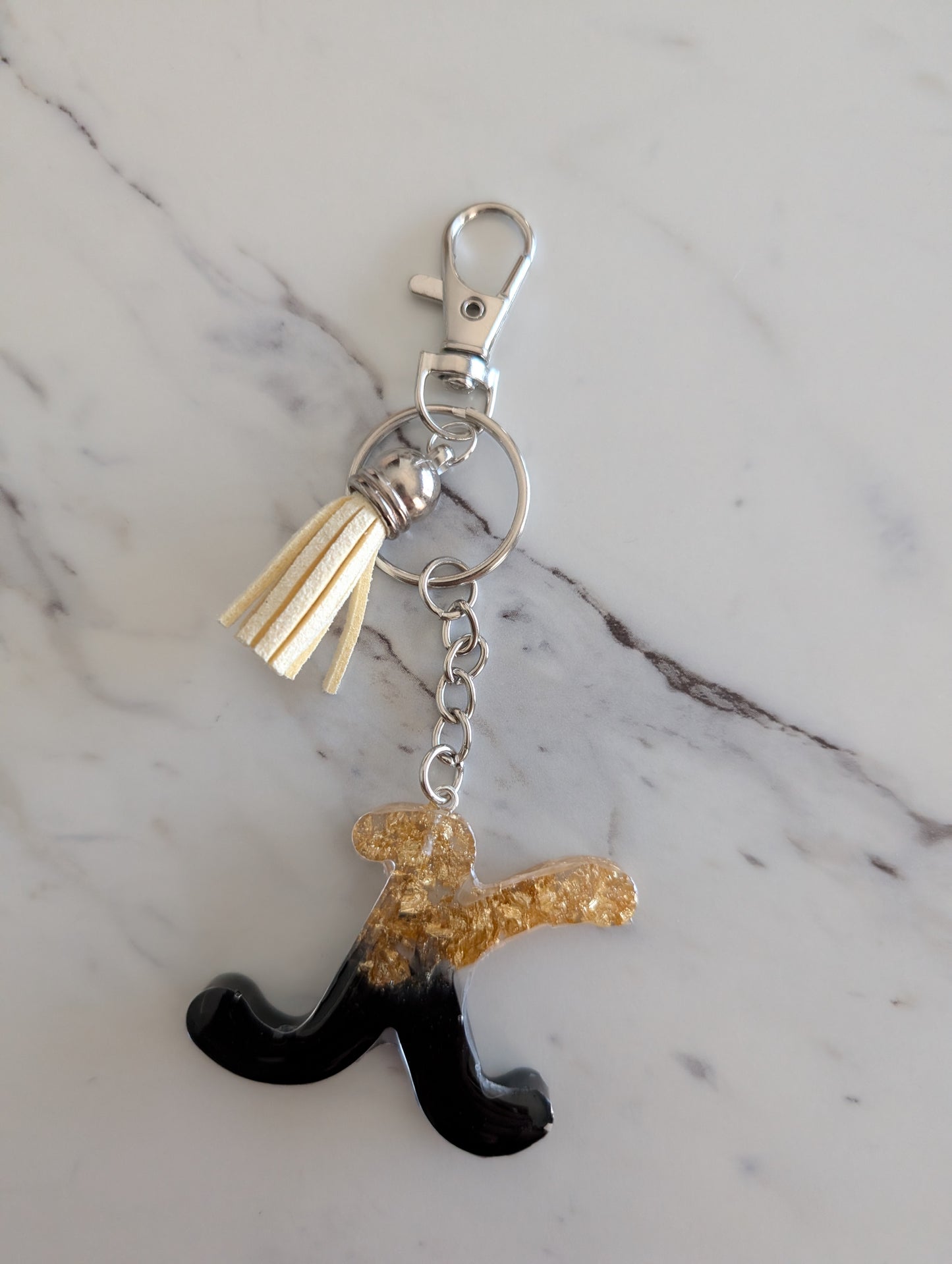 Keychain with a letter 'K' charm on a marble background