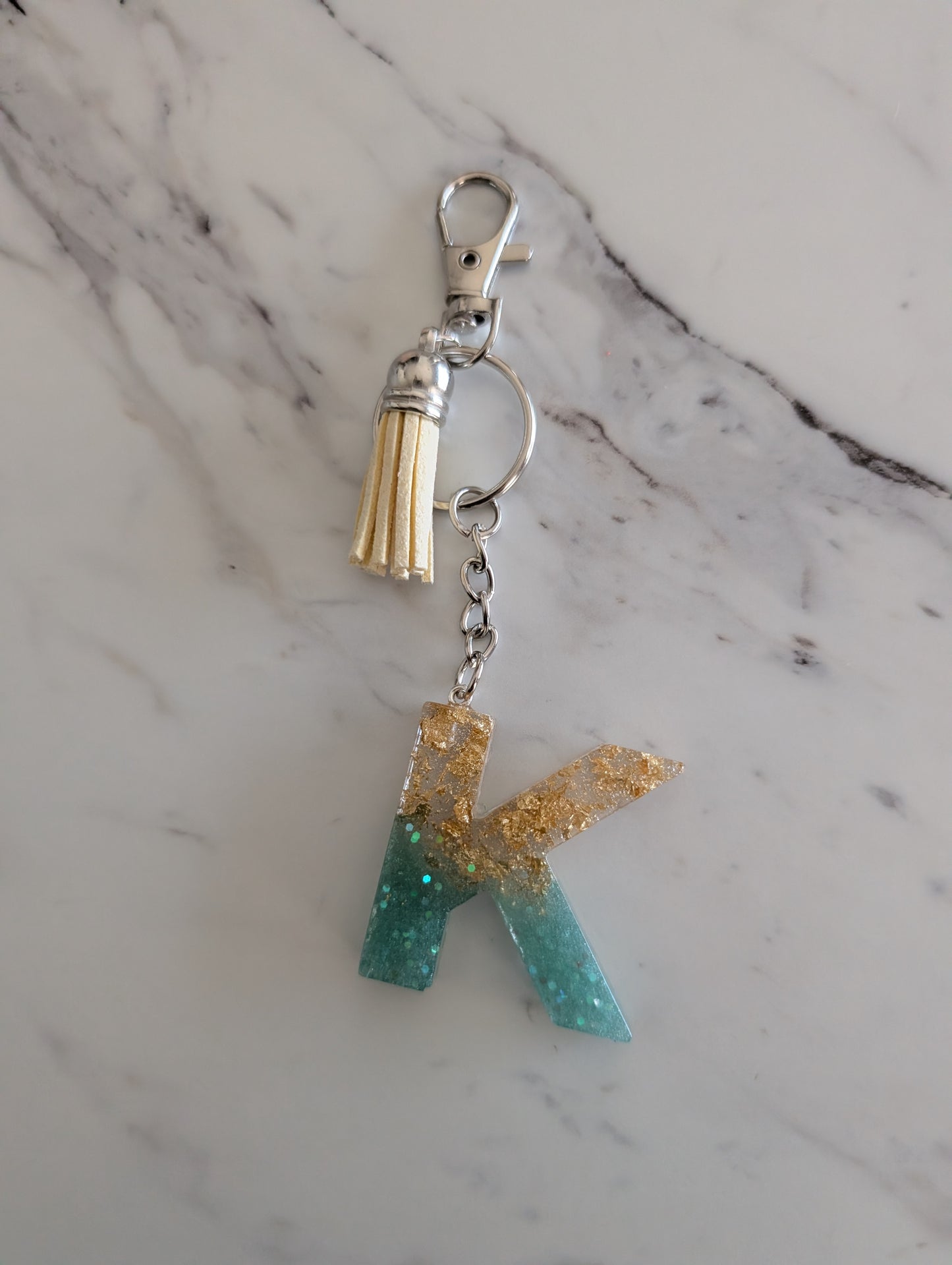 Keychain with letter 'K' charm on a marble background