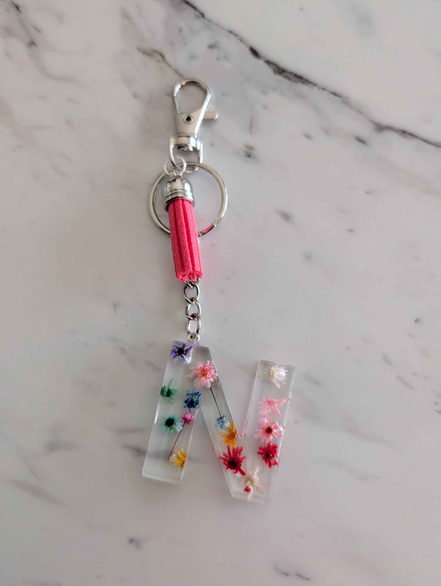 Letter N Keychain with floral design on a marble surface