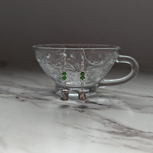 Clear glass teacup with earrings on a marble surface