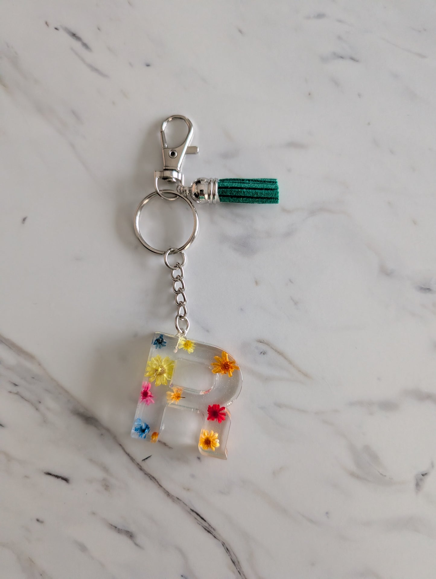 Letter R Keychain with colorful floral design on a marble surface