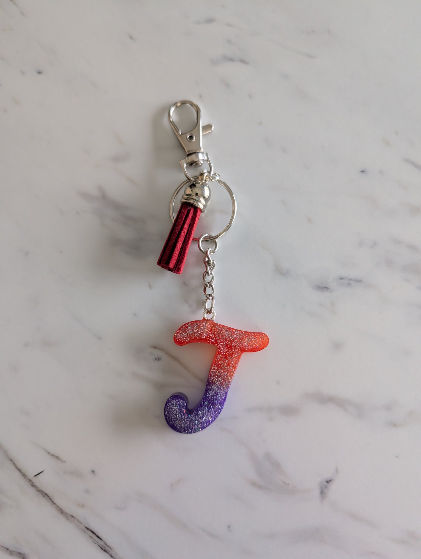 Keychain with letter 'T' on a marble surface