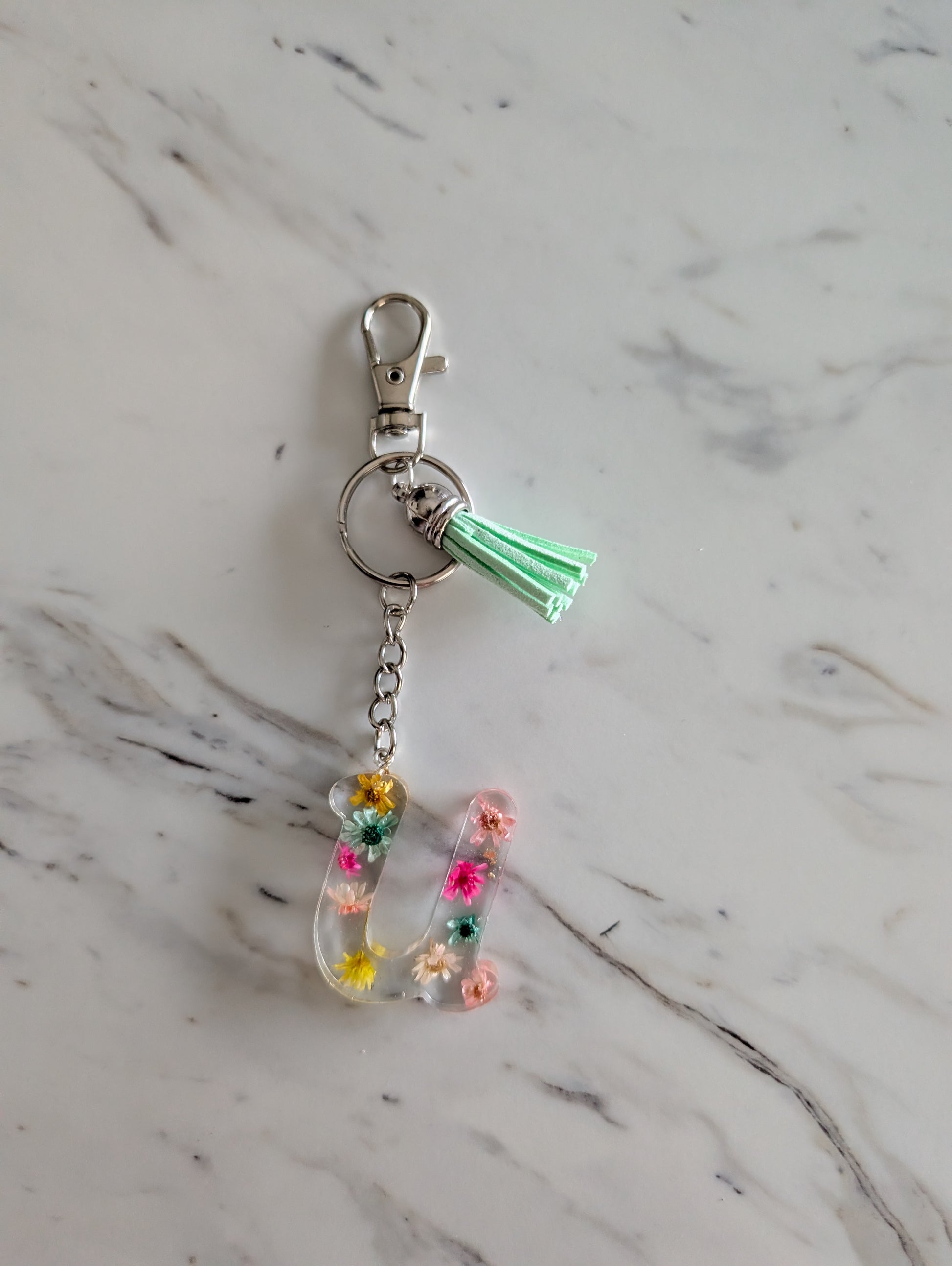 Letter U Keychain with colorful flowers and on a marble surface