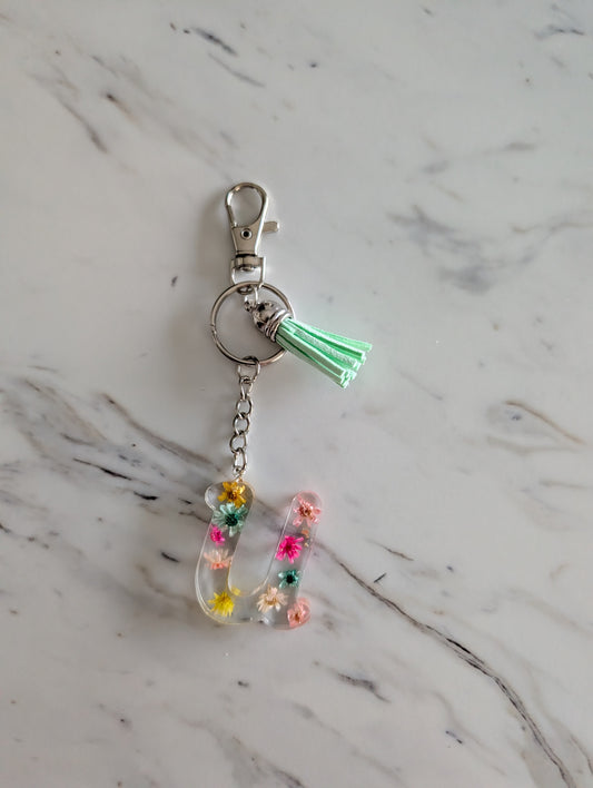 Letter U Keychain with colorful flowers and on a marble surface