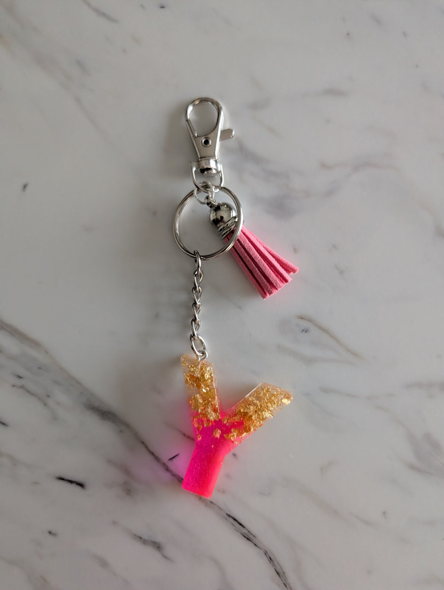 pink and gold letter Y keychain on a marble surface