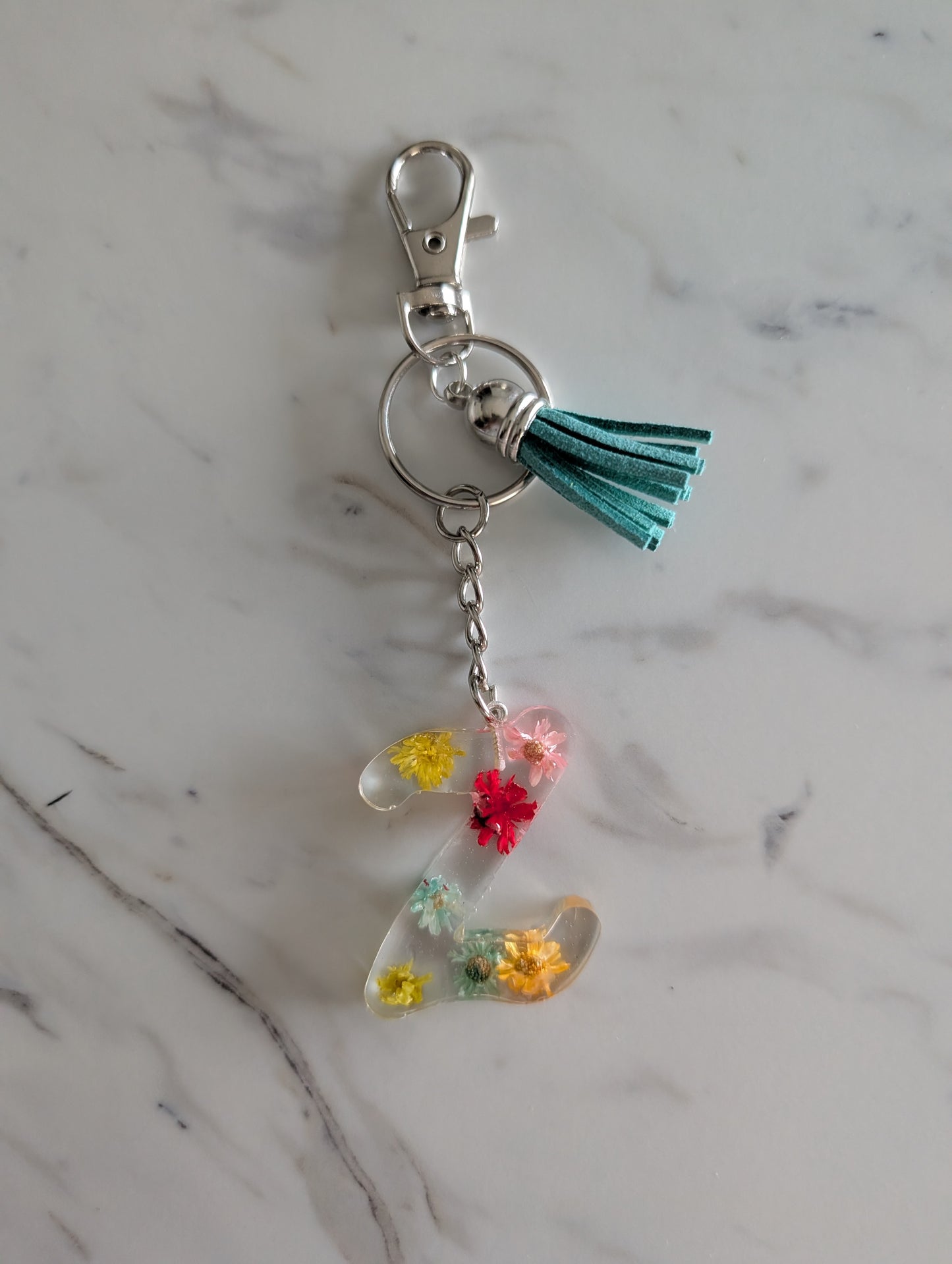 Letter Z Keychain with colorful flowers and a tassel on a marble surface