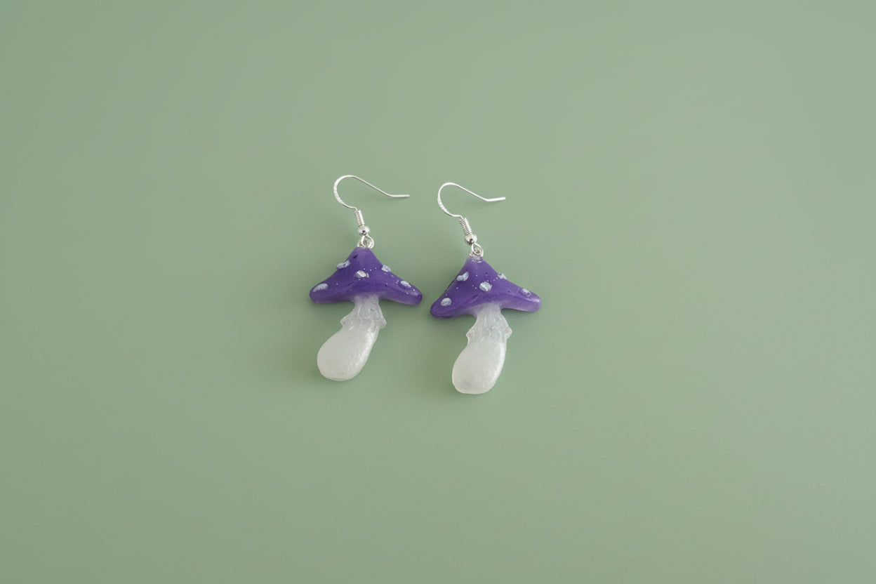 Mushroom-shaped earrings on a green background