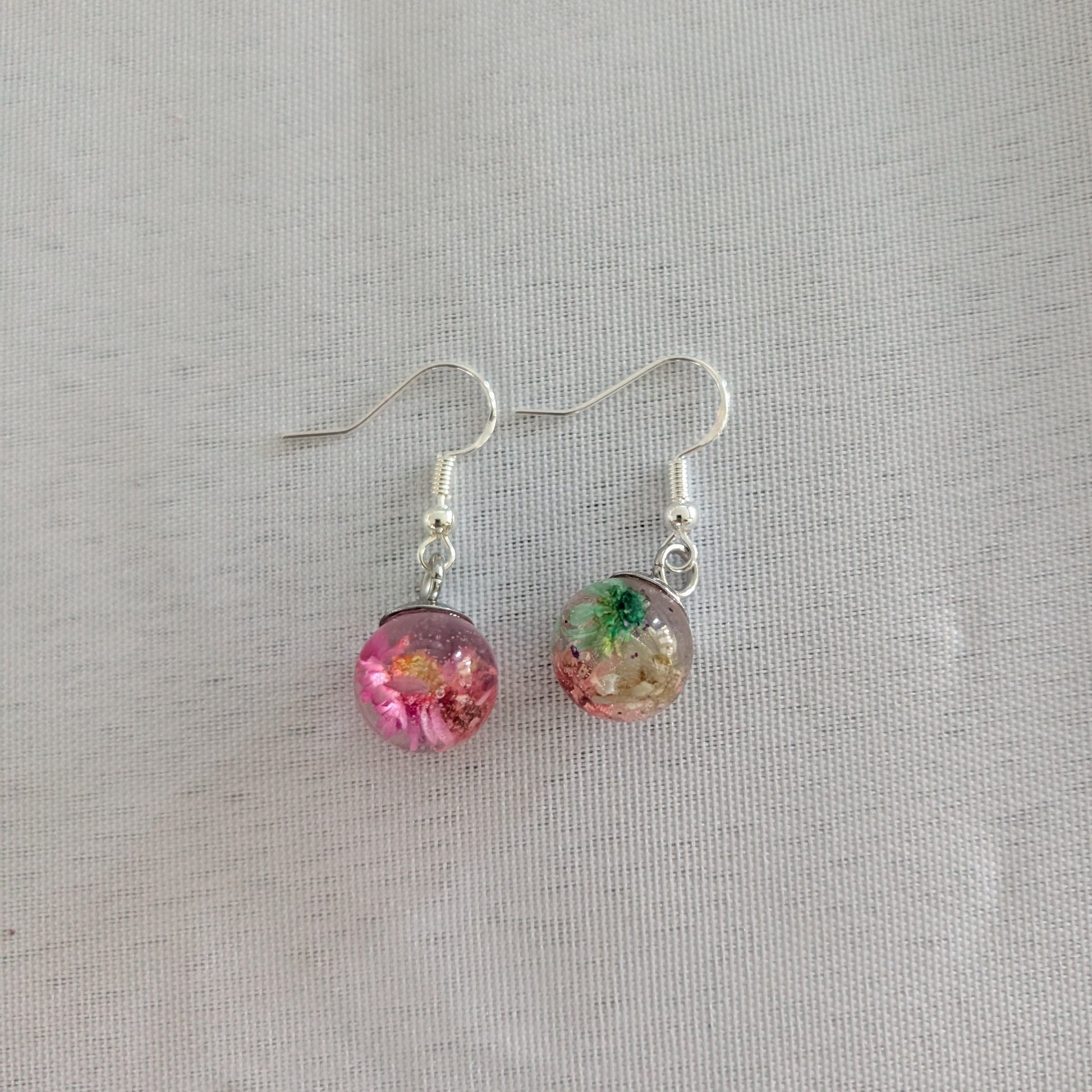 Pair of earrings with colorful beads on a light gray background