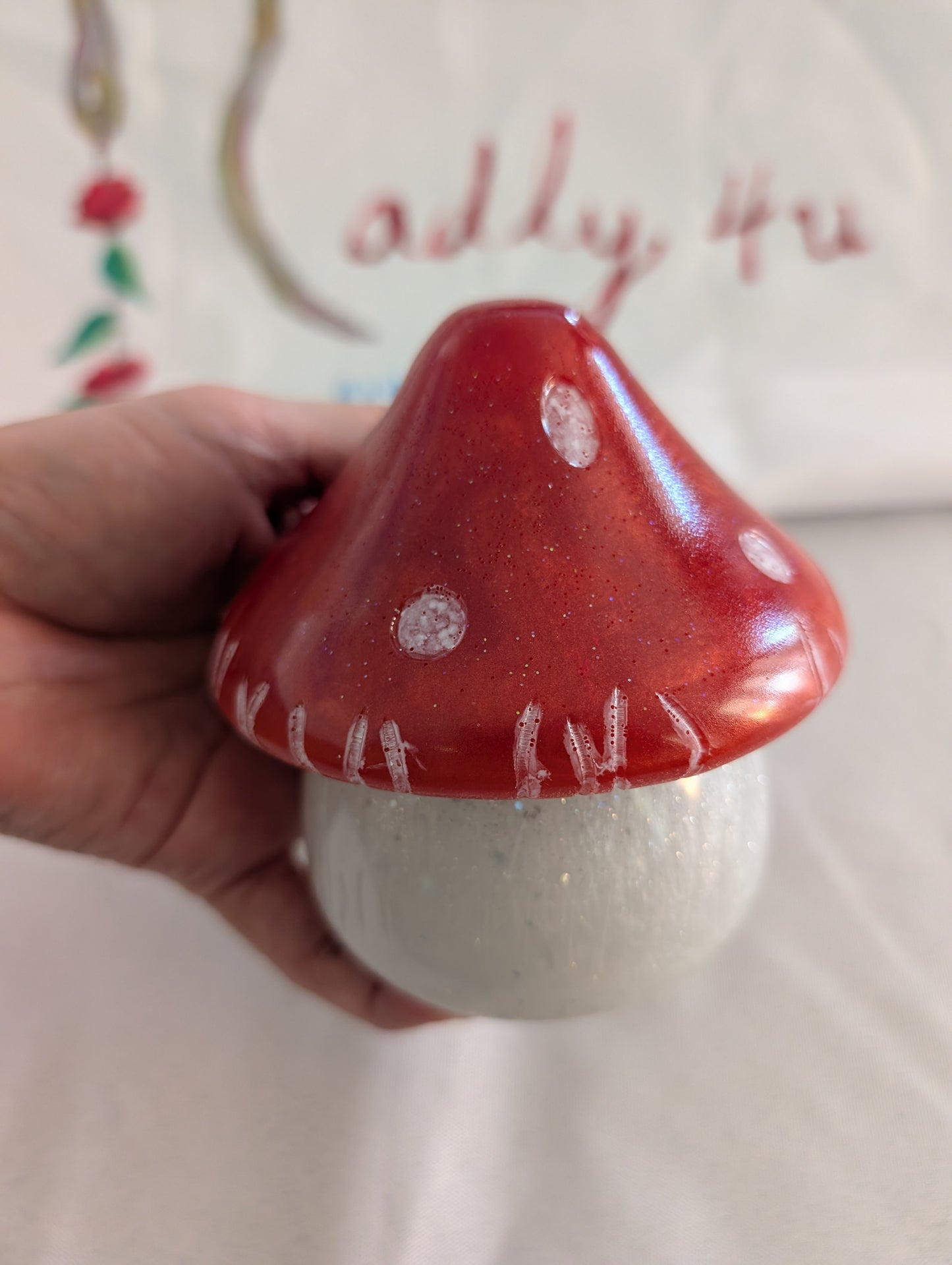 This charming hand-crafted resin mushroom trinket brings whimsical elegance to any space. Meticulously sculpted from epoxy resin, it features a smooth, glass-like finish that's both durable and non-porous—perfect for storing small treasures, jewelry, or keepsakes. The removable lid makes access effortless, while its compact 4.5-inch height and 4x4-inch width fit seamlessly on shelves, desks, or nightstands. At just 12.4 ounces, it's lightweight yet substantial enough to feel premium. Each piece showcases th