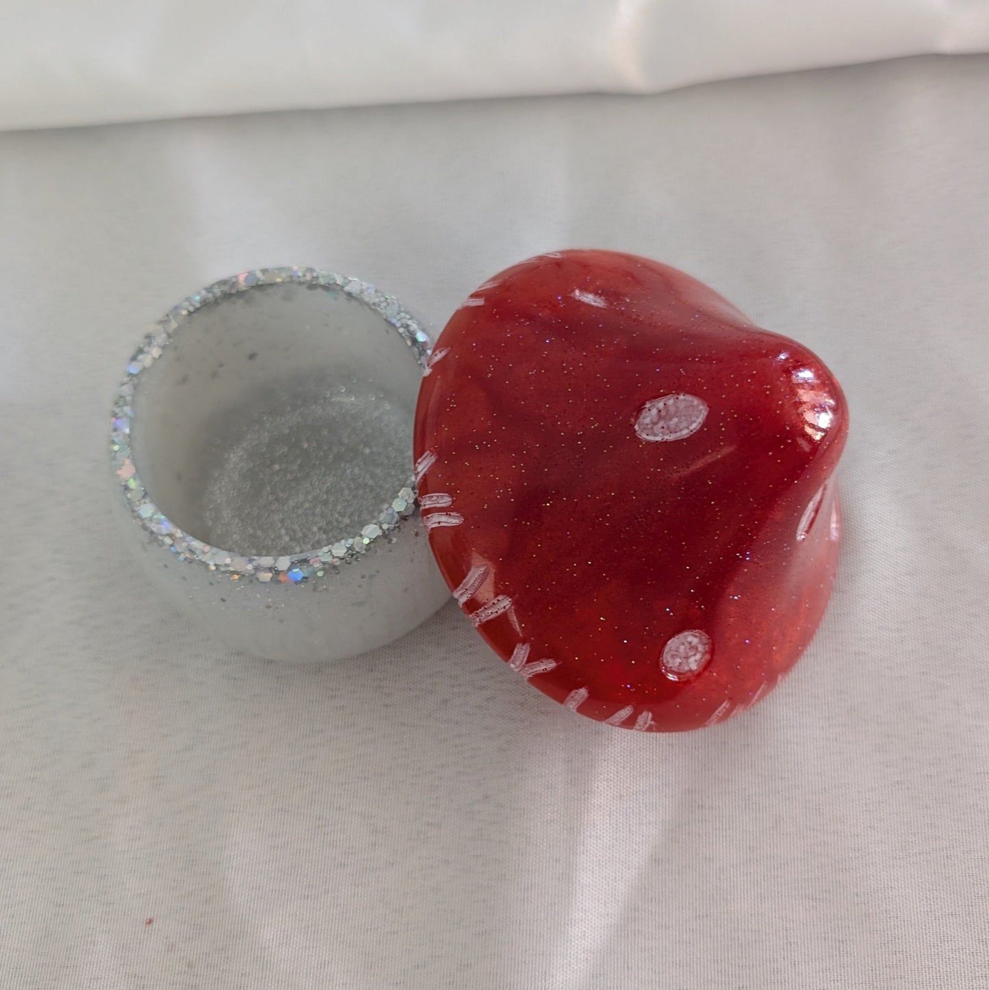 This charming hand-crafted resin mushroom trinket brings whimsical elegance to any space. Meticulously sculpted from epoxy resin, it features a smooth, glass-like finish that's both durable and non-porous—perfect for storing small treasures, jewelry, or keepsakes. The removable lid makes access effortless, while its compact 4.5-inch height and 4x4-inch width fit seamlessly on shelves, desks, or nightstands. At just 12.4 ounces, it's lightweight yet substantial enough to feel premium. Each piece showcases th