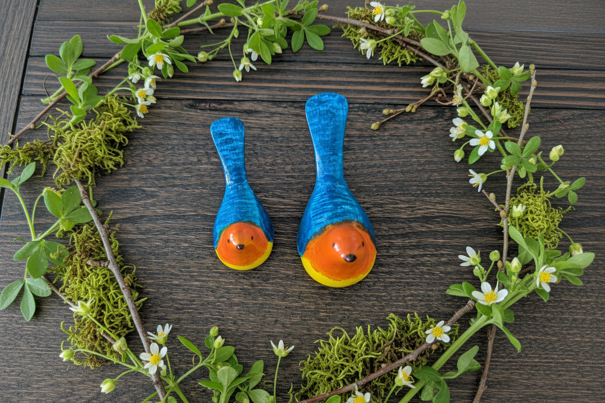 Two blue-wrapped spoons with orange and yellow ends on a wooden surface
