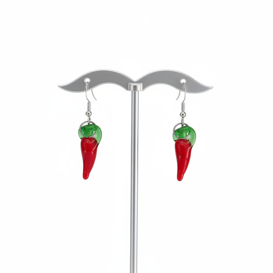 Red and green chili pepper earrings on a stand against a white background