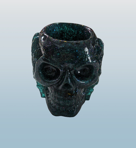 Green and glittery skull-shaped trinket holder on a light gray background