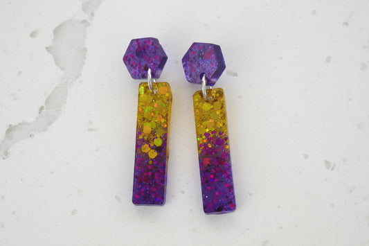 Colorful hexagonal and rectangular earrings on a white background