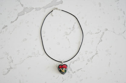 Necklace with a heart-shaped pendant on a light gray textured background