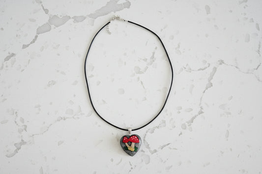 Necklace with a heart-shaped pendant on a light gray textured background
