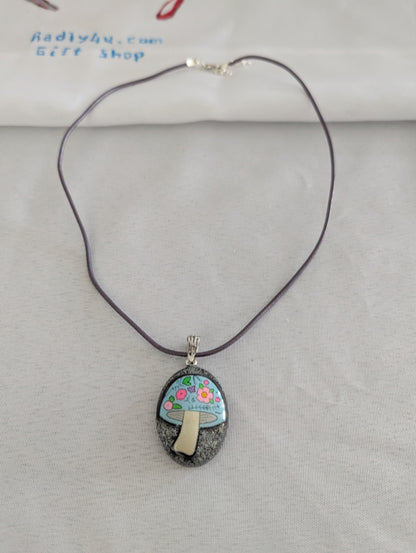 Necklace with a pendant featuring a mushroom design on a gray background