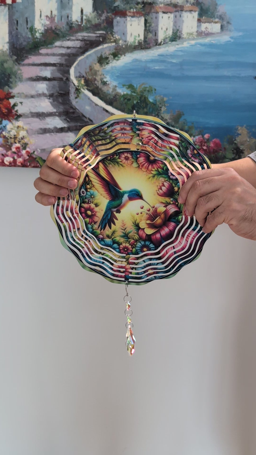 Metal hummingbird wind spinner for garden decor, outdoor hanging kinetic yard art.