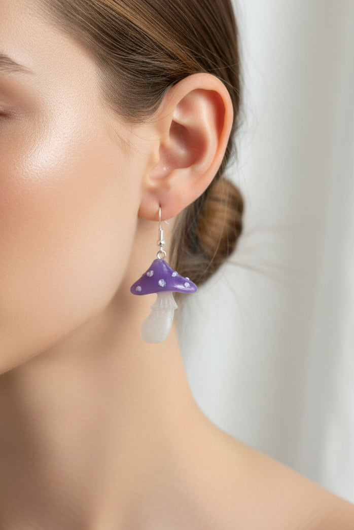 Close-up of a person wearing a purple mushroom earring.