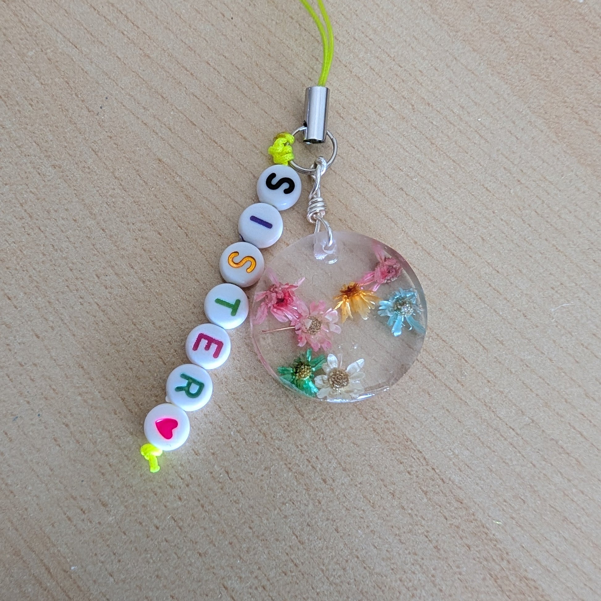 Spice up your phone with this charming resin charm, adorned with real dried flowers and beads. The 3.75 inch length adds a touch of flair to any device. (It's like a bouquet, but for your phone!)

Phone charm - Resin charm with dried flowers and beads